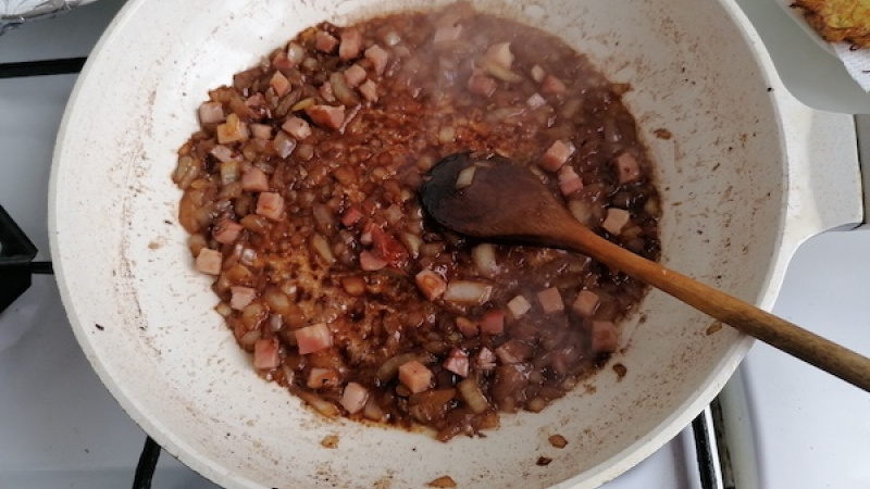 8. Pridáme ešte trochu oleja, na kocky nakrájanú cibuľu, po chvíľke slaninu a môžeme podliať trochou vody, nech sa nám výpek krásne poodlepuje. Podusíme krátko.