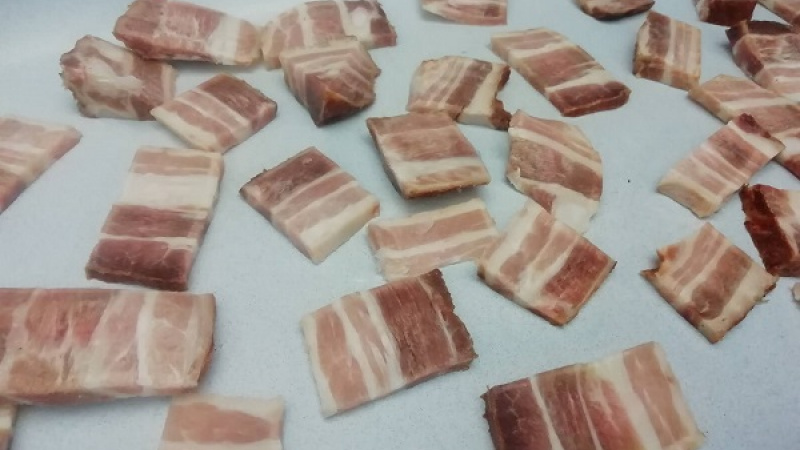 2. Do väčšieho pekáča alebo zapekacej misy rozložíme nakrájanú slaninu, olejom potierať netreba. Tak rozvrstvíme aj kyslú (kvasenú) kapustu, ktorú sme si vytlačili od vody.