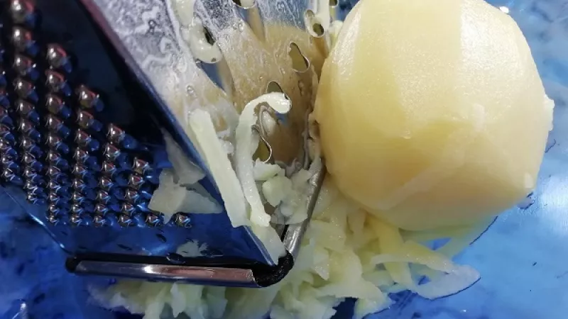2. Zemiaky ošúpeme, umyjeme a nastrúhame na menšie či väčšie rezance.