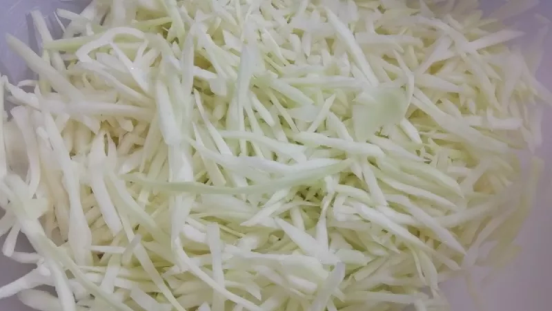 1. Hlávkovú bielu kapustu zbavíme hlúbika, nakrájame alebo nastrúhame na menšie rezančeky, môžeme nakrájať aj malé kocky. Cibuľu nakrájame nadrobno.