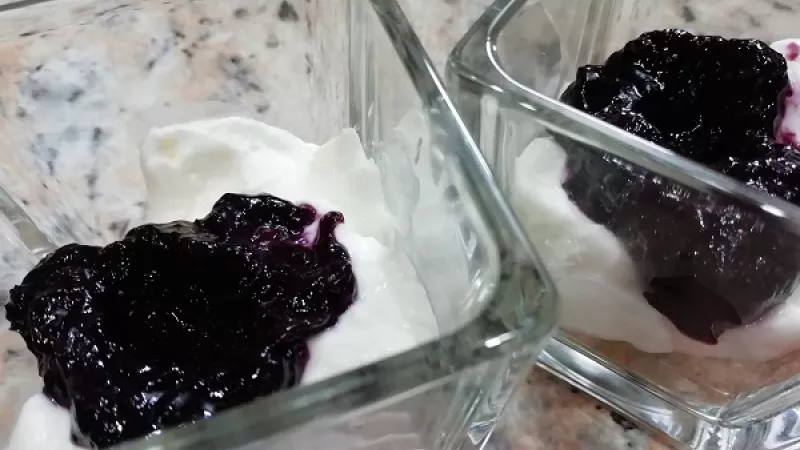 3. Do polovice krému primiešame 1/2 čučoriedkovej omáčky. Na dno pohárov rozdrobíme sušienky a vrstvíme jednotlivé krémy a omáčku podľa fantázie.