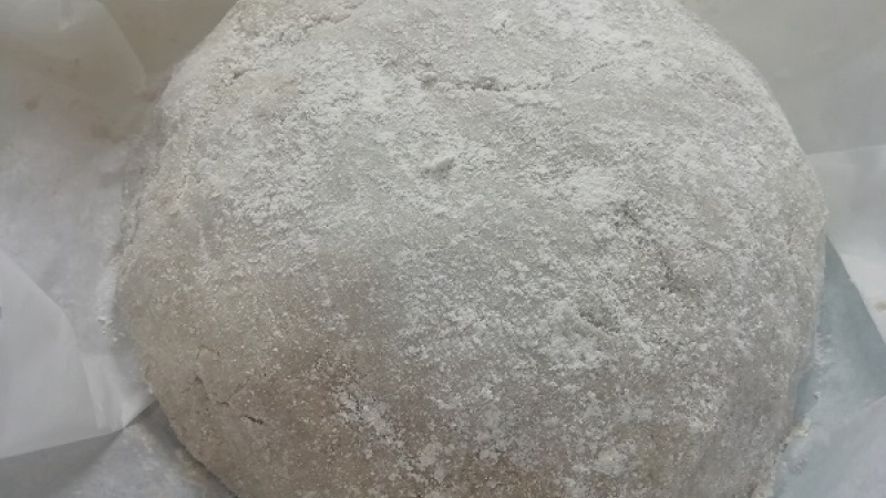 2. Potom ho rukami upravíme do tvaru bochníka. Cesto sa nesmie v žiadnom prípade miesiť. Misu z jenského skla alebo pekáč vystelieme papierom na pečenie. Na papier pomúčenými rukami uložíme bochník. Bochník posypeme ďalšou múkou.