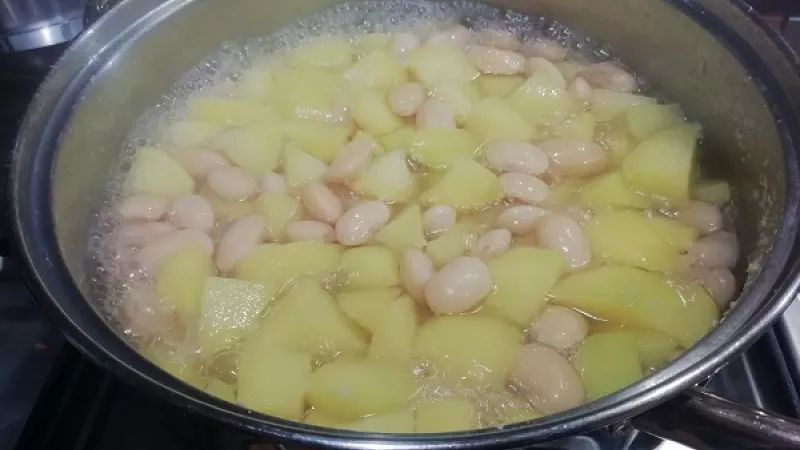 4. K polomäkkej fazuli pridáme zemiaky, môžeme pridať ešte aj trochu horúcej vody, aby boli aj zemiaky ponorené. Všetko spolu varíme do mäkka.