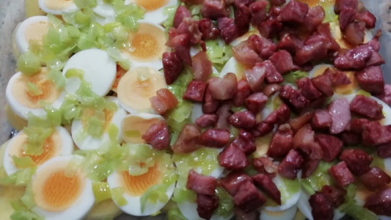 3. Pór rozvrstvíme po celej ploche vajec ako aj špekáčky (šunku), ktoré sme si nakrájali na malé kocky a poopekali na troche masla dozlatista. V našom prípade som opečenú šunku pridala iba na polovicu, pre verziu bez mäsa.