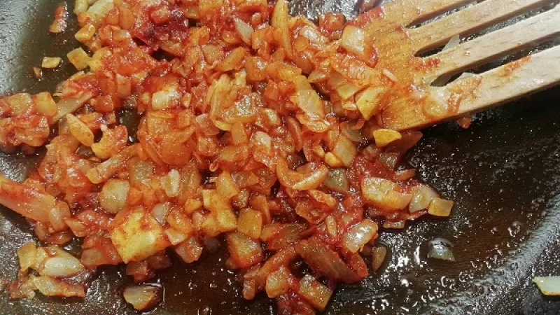 2. Zemiaky na miernom stupni opečieme. Cibuľu očistíme a nakrájame nadrobno. Na masle ju orestujeme do sklovita. Pridáme mletú červenú papriku.