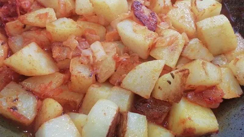 4. Ku zemiakom s cibuľovým paprikovým základom pridáme približne 2 dl horúcej vody. Panvicu prikryjeme a zemiaky dusíme do mäkka. Trvá to 15 minút.