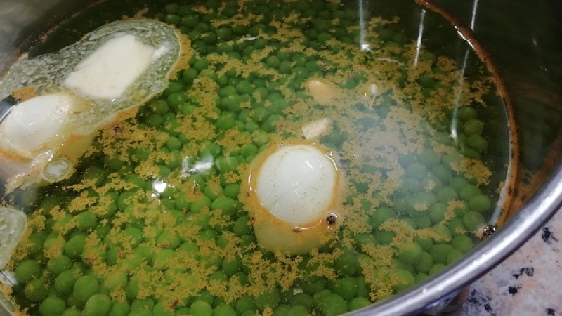 2. Do hrnca nalejeme 2 l vody, pridáme mrazený hrášok, maslo, očistenú rozpolenú cibuľu, očistený cesnak, korenie podľa chuti.