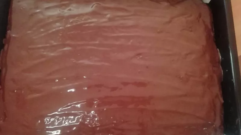 8. Pripravíme si čokoládovú polevu. Nad vodným kúpeľom v miske si roztopíme čokoládu s olejom a polejeme náš koláč.