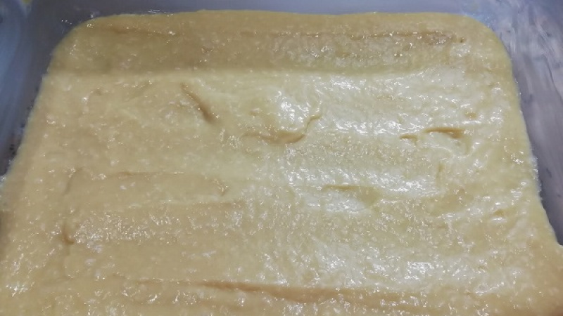 5. Plech na pečenie (veľkosti cca 25x18 cm) dôkladne vymastíme maslom a tak si rozotrieme polovicu cesta.