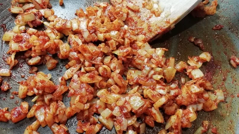 3. Pridáme vytlačené huby, koreniny, rozpolený cesnak. Polievku dáme variť. Na (olivovom) oleji orestujeme do sklovita nakrájanú cibuľu, zasypeme červenou paprikou.