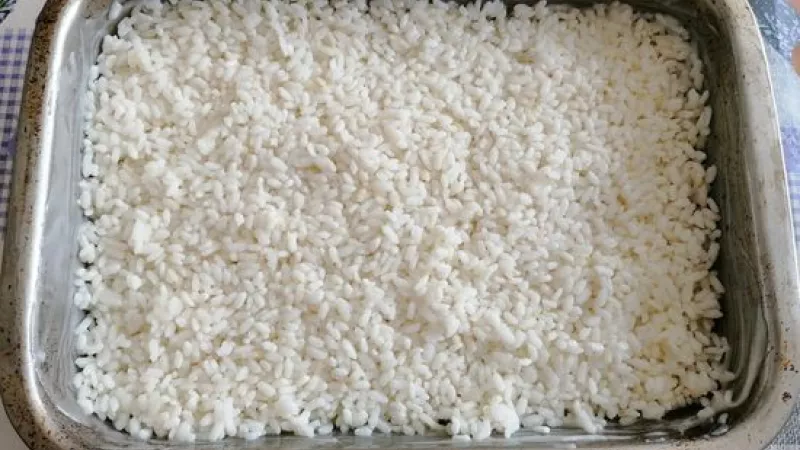 1. Predvaríme si ryžu (asi 10 minút) a dáme ju na spodok vymasteného plechu.

