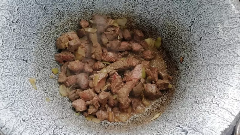 2. Do kotlíka pridáme bravčovú masť alebo olej a pripravenú cibuľu, orestujeme ju do sklovita. K orestovanej cibuli pridáme mletú červenú papriku, môžeme aj pálivú, podľa chuti. Premiešame.