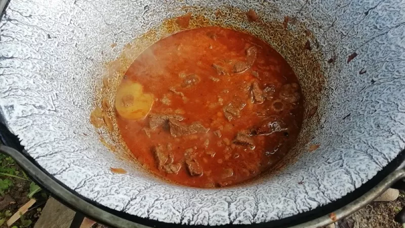 4. K mäsu pridáme aj 1 ošúpaný, umytý a rozpolený zemiak, ktorý až nakoniec, keď bude mäkký rozštucháme. Takto guláš zahustíme bez pridania múky. Mäso ďalej dusíme za stáleho podlievania.