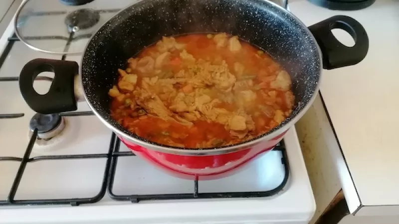 2. Pridáme mletú papriku a hneď aj mäso nakrájané na kocky, tiež s kosťami (prvý trik: ak sa dusí mäso aj s kosťami, pustí viac chuti). Tiež čierne korenie. Zalejeme len množstvom vody, aby bolo akurát ponorené. Prikryjeme pokrievkou a dusíme 30 minút.