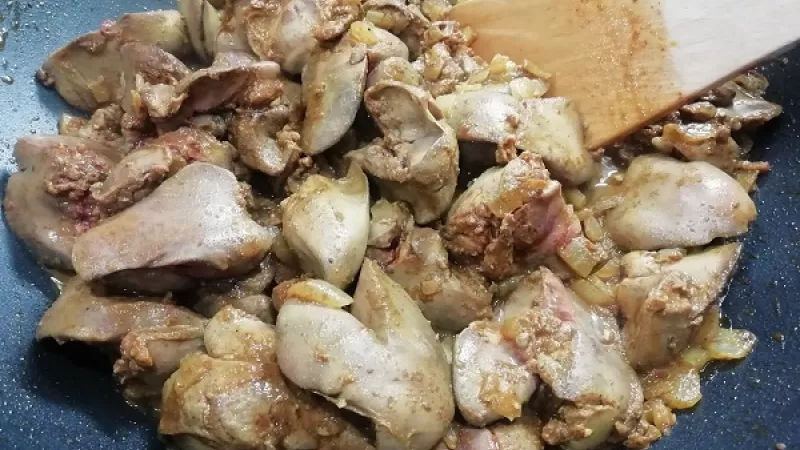 4. Keď sa pečeň zatiahne (zbledne) pridáme roztlačený cesnak, premiešame a chvíľu restujeme. Pridáme obvarený zelený hrášok.