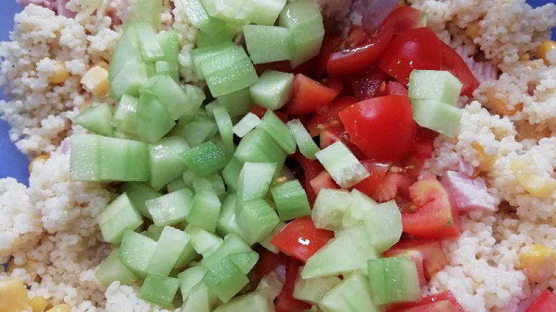 3. Ku kuskusu pridáme hustý biely jogurt, nakrájanú šunku a kukuricu podľa výberu. Pripravíme si aj paradajky, uhorku, hrozno, ktoré umyjeme, uhorku môžeme aj ošúpať. Všetko nakrájame na menšie kocky, rezančeky. 