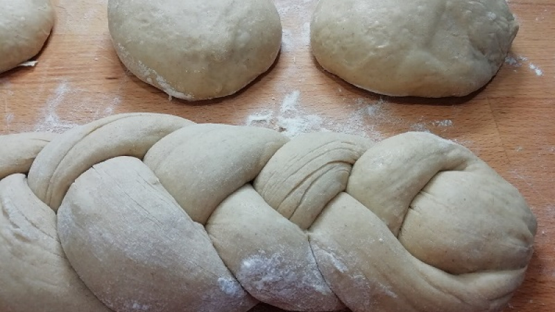 5. Kváskové bochníky na vianočku si necháme na drevenej doske ešte 20 minút podkysnúť. Je však potrebné ich prikryť fóliou. Z troch bochníčkov si urobíme cca 40 cm dlhé šúľky. Konce stlačíme, zahneme dovnútra a upletieme jednoduchý a hustý vrkoč.