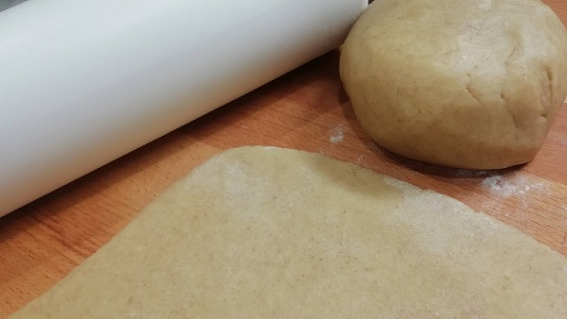 2. Postupne zapracujeme múku. Vypracujeme bochník, zabalíme do fólie, necháme v chlade odpočívať 2 hodiny. Vykvasené cesto rozdelíme na dve časti, vyvaľkáme.