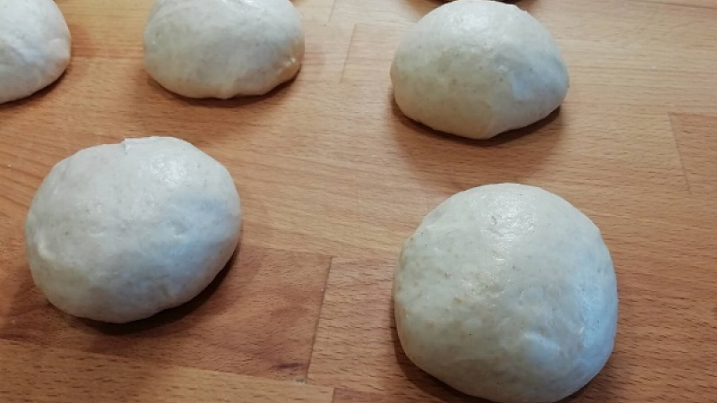 4. Cesto zo špaldovej múky je elastické, veľmi dobre sa s ním pracuje. Ak máme pocit, že sa lepí, použijeme ďalšiu múku. Celé cesto  odvážime, celkovú gramáž vydelíme počtom 12. Urobíme si 12 bochníčkov, ktoré si opäť premiesime a prikryjeme fóliou.