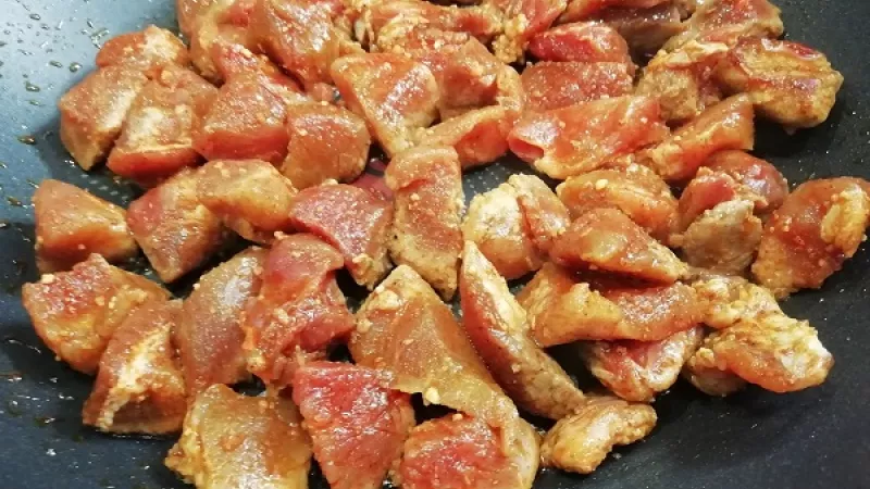 2. Na opekanie minútky zvolíme väčšiu kvalitnú panvicu, ktorú dobré rozohrejeme. Pridáme marinované bravčové kúsky, ktoré prudko opekáme z každej strany.