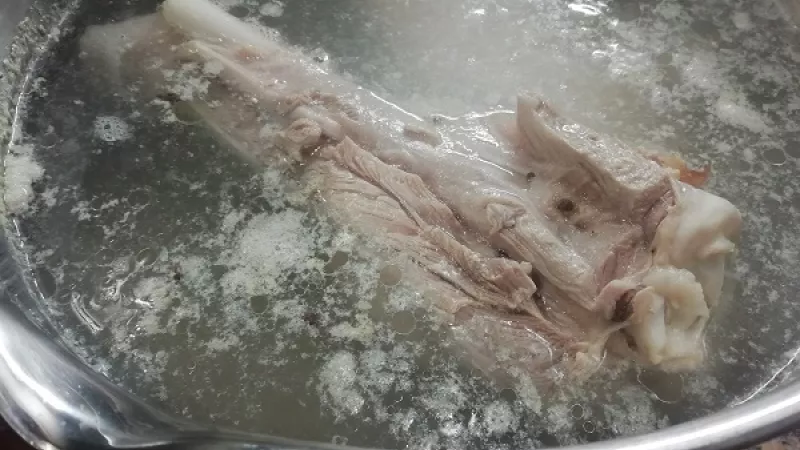 3. Mäso dáme do hrnca, zalejeme vodou. Privedieme do varu, dierovanou naberačkou odstránime penu.