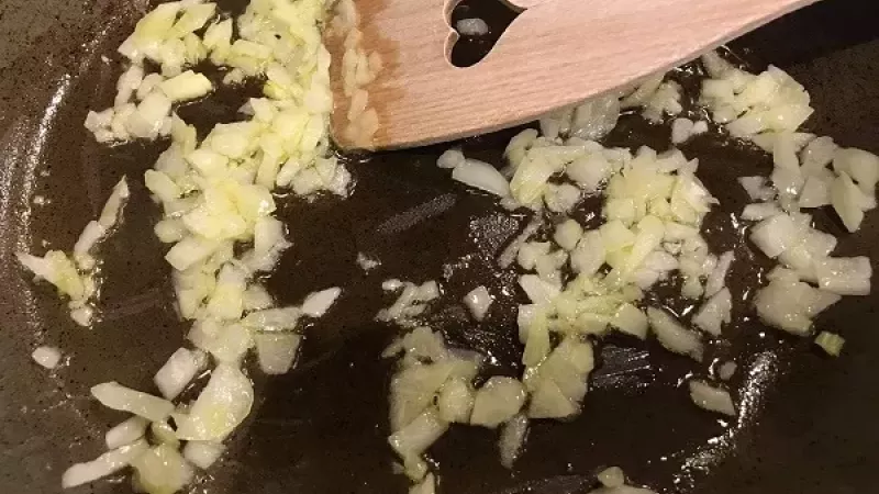 2. Kvalitnejšiu panvicu rozohrejeme, pridáme kúsok masla (lepšia chuť) alebo olej a nadrobno nakrájanú cibuľu. Cibuľu si opražíme do sklovita.