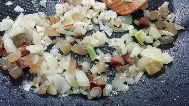 2. Cuketu umyjeme a nastrúhame. Cibuľu očistíme a nakrájame nadrobno, slaninku na malé kocky. Slaninu opražíme, aby pustila tuk. Cibuľu orestujeme na slanine (masle) do sklovita, pridáme roztlačený cesnak.