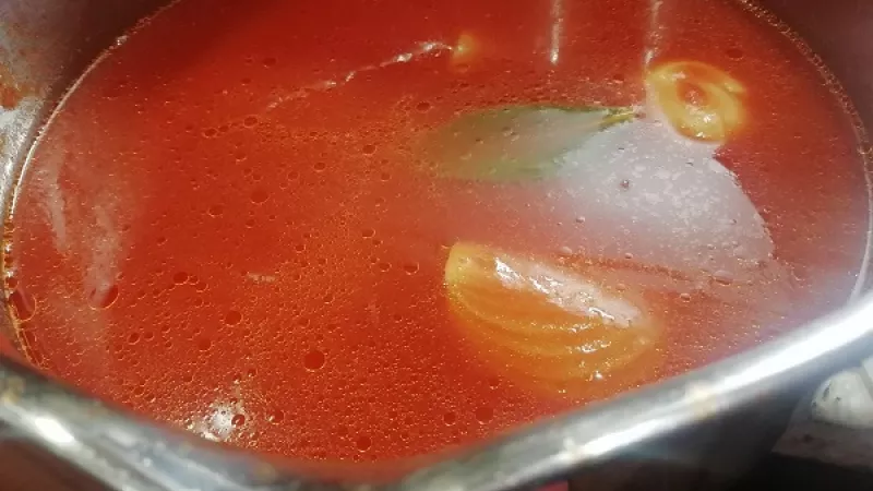 2. Takto pripravené paradajkové pyré s koreninami restujeme cca 5 minút. Potrebujeme, aby sa pyré opražilo. Robíme to však na jemnom stupni, za miešania. Po 5 minútach nalejeme do hrnca pohár (250 ml) horúcej vody. Polievku necháme variť ďalších 10 minút.