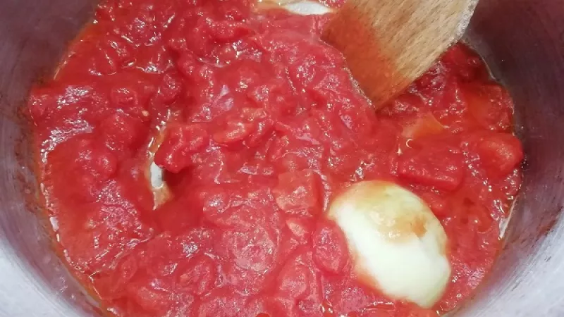 2. Cibuľu očistíme a rozrežeme napoly. Do hrnca pridáme maslo, keď sa roztopí, vložíme rozpolenú cibuľu. Chvíľu opražíme. Cibuľa nám pekne zavonia. Pridáme polené paradajky a trochu cukru, ale aj ostatné korenie podľa chuti. Orestujeme.