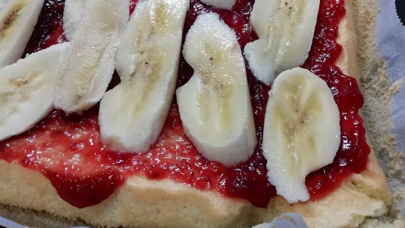 12. Banány narežeme na tenšie kúsky, poukladáme ich po celej ploche koláča. Môžeme ich aj vynechať.