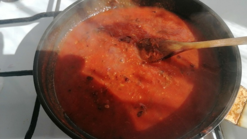2. Pridáme dva strúčiky nastrúhaného cesnaku a keď začne voňať, zalejeme paradajkami, dochutíme čiernym korením a chvíľu povaríme.