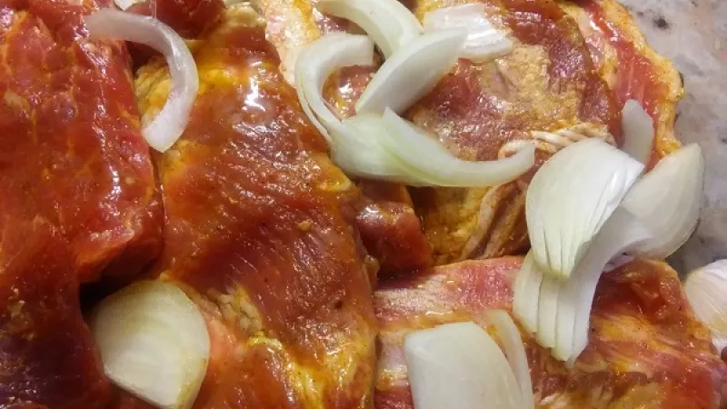 2. Do zapekacej misy alebo pekáča poukladáme odležané bravčové rebierka, pridáme očistenú, na plátky nakrájanú cibuľu, očistený celý cesnak, bobkový list a polejeme obľúbeným pivom izbovej teploty. Pekáč si prikryjeme alobalom, rebierka dáme piecť.