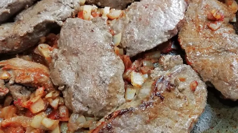6. K cibuli pridáme červenú papriku, premiešame, pridáme plátky roštenky. Panvicu prikryjeme, mäso dusíme 5 minút, pustí šťavu.