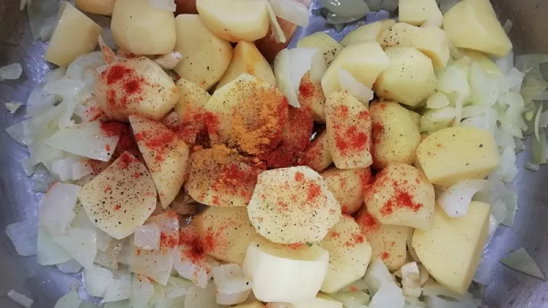 2. Keď cesnak zavonia, pridáme na menšie kocky nakrájané zemiaky, ktoré sme očistili a dôkladne umyli. Chvíľu opekáme.