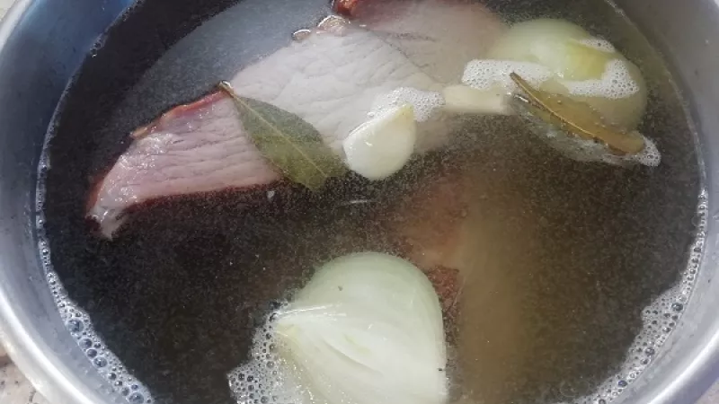 2. Vodu necháme zovrieť. Údenú šunku vkladáme zásadne do vriacej vody. Necháme, aby voda opäť zovrela, povaríme 3 minútky, potom znížime plameň a varíme na miernom stupni. Takýmto spôsobom sa údené mäso zatiahne a šťava ostane vo vnútri.