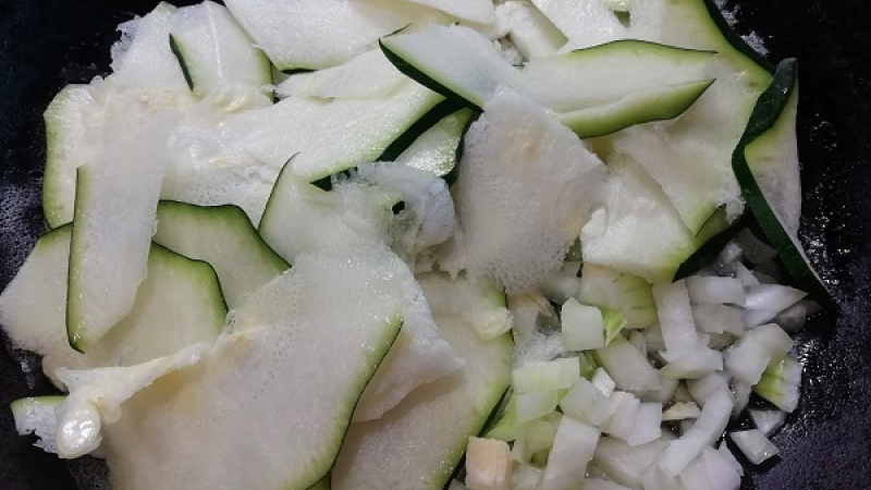 3. Pridáme aj plátky cesnaku. Keď cesnak zavonia, vložíme pripravenú cuketu. Cuketa nastrúhaná na rezančeky je omnoho rýchlejšia na prípravu.