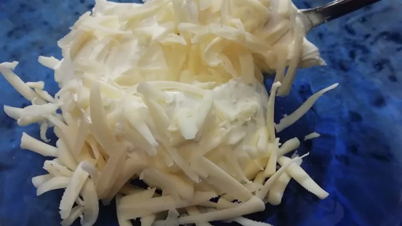 1. Do misky pridáme smotanovú nátierku a Ramu (maslo), vymiešame. Primiešame aj nastrúhaný tvrdý syr.