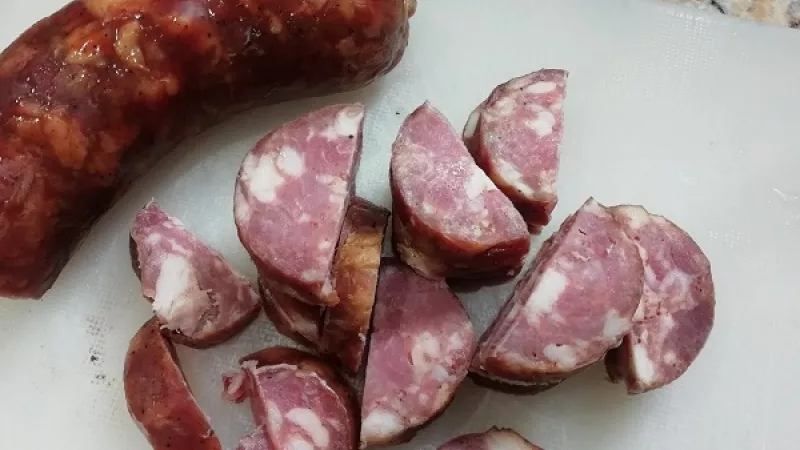 6. Klobásu nakrájame na menšie kúsky, pridáme k vareniu jušky. Na jemnom stupni povaríme. Do mačanky pridáme aj mäso, keď je už mäkké. Samozrejme, záleží aký druh zvolíme. Pripravíme zálievku.
