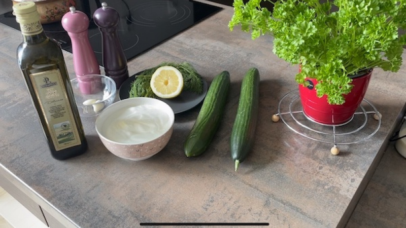 Ingrediencie (8 porcií): 2 šalátové uhorky, 2 polievkové lyžice nakrájaného čerstvého kôpru, 500 gramov bieleho (hustého) gréckeho jogurtu, trošku soli, trošku čierneho korenia, 2 strúčiky cesnaku, 2 polievkové lyžice šťavy z citróna, 1 deci olivového olej