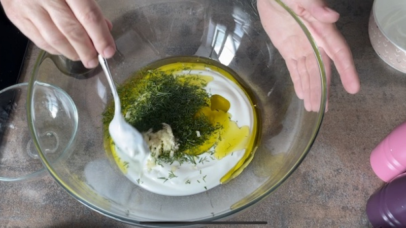 2. Zamiešame si jogurtovú zmes. Postupne pridáme hustý grécky jogurt, olivový olej, kôpor, citrónovú šťavu a roztlačený cesnak. Podľa chuti osolíme, okoreníme a zmes riadne premiešame.