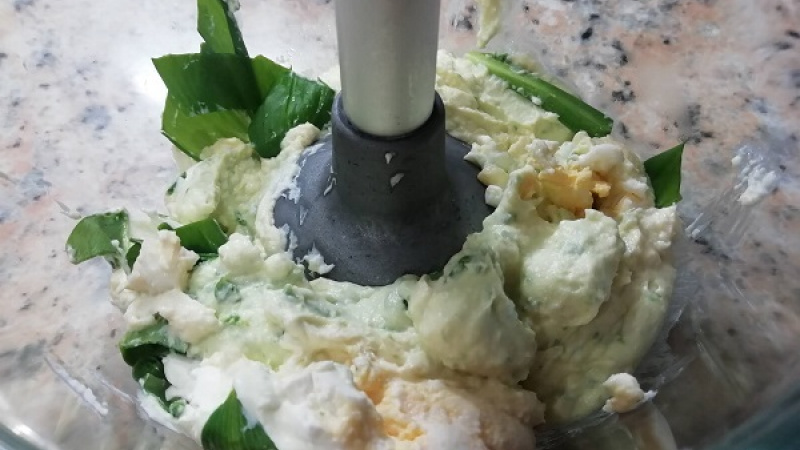 2. Do mixéra pridáme maslo, smotanovú nátierku, olúpané vajcia a nakrájaný medvedí cesnak.