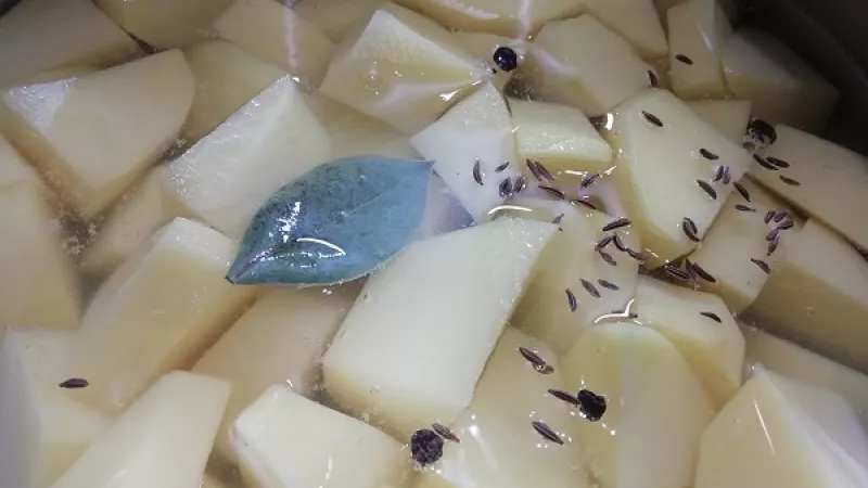 2. Takto pripravené zemiaky zalejeme vodou do ich výšky, pridáme soľ, čierne korenie, rascu,   bobkový list.