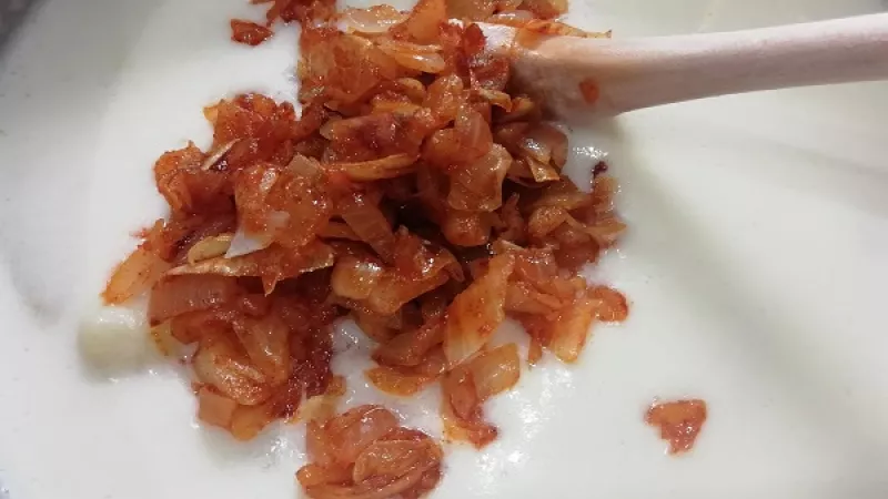 6. Smotanové zemiaky povaríme na jemnom stupni ešte 10 minút, aby zhustli.  Pridáme paprikovú cibuľu.