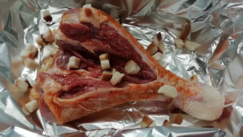 1. Morčacie stehná umyjeme, osušíme, okoreníme. V strede ich prekrojíme, aby sa lepšie prepiekli. Pekáč vystelieme alobalom, rátame aj s časťou na prekrytie.